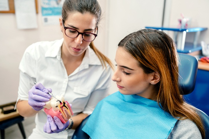 Dentist explaining gum issues with a dental model to a patient in a South Bend, IN, dental clinic